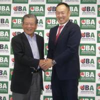 Tomoya Higashino (right) and Japan Basketball Association president Saburo Kawabuchi pose for photos during a news conference at the JBA office on Thursday. Higashino hopes to bring change to Japanese basketball