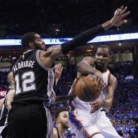 Oklahoma City's Kevin Durant (right) passes the ball around San Antonio's LaMarcus Aldridge during Game 6 of their playoff series on Thursday. The Thunder won 113-99. Thunder oust Spurs to reach West finals