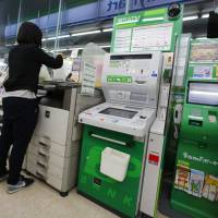 A woman uses a copy machine next to an ATM at a Tokyo convenience store Tuesday. Japanese banks that lost some ¥1.8 billion when fake overseas cards were used at convenience store ATMs are scrambling to combat such fraud. Japanese banks raise guard after ¥1.8 billion taken from ATMs