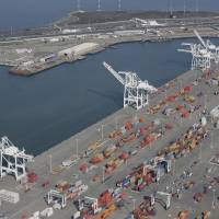 The former Oakland Army Base pier at left and the Port of Oakland at lower right are seen in February in Oakland, California. The promise of good, blue-collar jobs in a depressed area is running headlong into environmental sensitivities as officials in Northern California consider a plan to build a marine terminal that would serve as a gateway for Utah-mined coal heading to Asia. The terminal is in West Oakland, a historically black neighborhood that's among the poorest and most polluted in the region. Jobs vs. environment as smoggy Oakland weighs coal train terminal plan