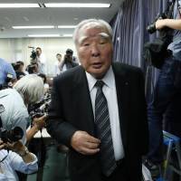 Osamu Suzuki, chairman of Suzuki Motor Corp., leaves a news conference at the transport ministry in Tokyo on May 18. Suzuki HQ searched over fuel-efficiency scandal