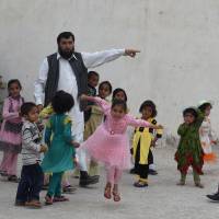 Sardar Jan Mohammad Khilji plays with some of his 35 children at his residence in Quetta, Pakistan, on March 23. Citing religious duty, Pakistani father of 35 aims to one day have 100 children