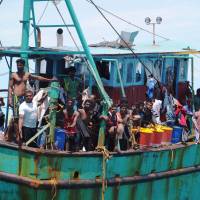 Dozens of Sri Lankan immigrants bound for Australia are seen stranded off Aceh in northwest Indonesia on their broken down boat on June 12. Indonesia lets migrants ashore after week on stranded boat