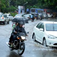 Indian commuters make their way along a waterlogged road during heavy monsoon rains in Kochi on June 8. British, Indian scientists to use underwater robots in study of subcontinent's monsoon