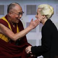 The Dalai Lama greets Lady Gaga before a question and answer session at the U.S. Conference of Mayors in Indianapolis on Sunday. Lady Gaga reportedly banned from China after Dalai Lama meeting