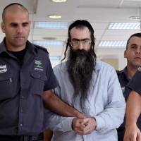 Ultra-Orthodox Jew Yishai Shlissel, who was convicted of attacking the Jerusalem Gay Pride parade in July last year in which a 16-year-old Israeli girl was stabbed and who later died, is escorted into the Jerusalem District Court by policemen on Sunday. Jewish man who stabbed Jerusalem Gay Pride marchers sentenced to life in prison