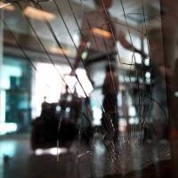 A traveler passes broken windows at the arrivals hall at Ataturk Airport Wednesday. Suicide attackers killed dozens and wounded more than 140 at Istanbul's busy Ataturk Airport late Tuesday, the latest in a series of bombings to strike Turkey in recent months. Turkish authorities have banned distribution of images relating to the Ataturk airport attack within Turkey. Like Islamic State Brussels attackers, Istanbul bombers came by taxi, sought lethal opportunity