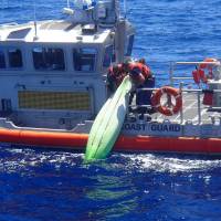 A United States Coast Guard patrol boat crew lifts a kayak found among debris near Sanibel, Florida, during a search for a family that went missing on their sailboat, in a picture released by the USCG on Wednesday. Gulf search continues for Florida family missing on sailboat after second body found