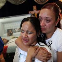 The body of Angel Candelario, one of the victims of the shooting at the Pulse nightclub in Orlando, Florida, lies in a coffin as family and friends mourn at his wake in his hometown of Guanica, Puerto Rico, on Friday. Orlando begins to bury its dead in wake of Pulse gay club mass shooting