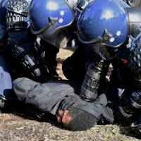 Riot police hold a protester on the ground during clashes between anti-racism and anti-immigration activists at rallies located near Victoria state's Parliament House in Melbourne, Australia, on Sunday. Three arrested during violence at rival immigration protests in Melbourne