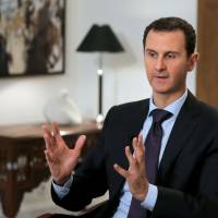 Syrian President Bashar Assad gestures during an interview in Damascus on February 11, 2016. Syria's Assad names new prime minister
