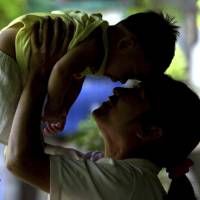 An HIV-positive mother plays with her son, who did not contract the virus from her, in Phetchaburi province, south of Bangkok, in this file photo from June 17, 2004. Thailand is first Asian country to reach milestone on eliminating HIV