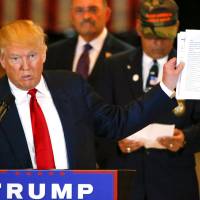 U.S. Republican presidential candidate Donald Trump holds paperwork that states Donald J. Trump, Veteran Fundraiser during a news conference at Trump Tower in Manhattan, New York, Tuesday. Trump turns testy toward press, claims he got no credit for raising $5.6 million for vets