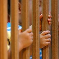 Children are seen through a baby safety gate as they play at Futaba Baby Home in Tokyo on June 21. Child welfare law revised but tens of thousands remain institutionalized in Japan