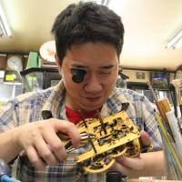 Yoshiki Nakano repairs an old wind-up clock at his shop in Matsusaka, Mie Prefecture. Business ticks on for artisan clockmakers as wind-up timepieces find renewed favor