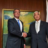 U.S. Secretary of Defense Ash Carter and Japanese Defense Minister Gen Nakatani shake hands during a bilateral meeting Saturday on the sidelines of the 15th International Institute for Strategic Studies (IISS) Shangri-La Dialogue in Singapore. U.S. to review status of civilian workers at Japanese military bases
