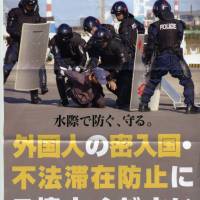 Keen on the rough stuff: A poster put up by the Ibaraki police in 2007 show the prefecture's boys in blue tackling assumed illegal foreign invaders. Japan's police still unfettered by the law, or the truth