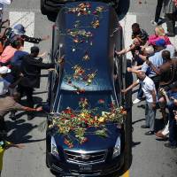 Well-wishers touch the hearse carrying the body of Muhammad Ali during the funeral procession through his hometown of Louisville, Kentucky, on Friday. Final bell tolls for The Greatest