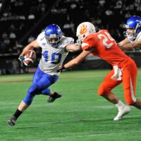 IBM tight end John Stanton uses a stiff arm to avoid a tackle during Monday's Pearl Bowl final. IBM Big Blue edge Lixil Deers for Pearl Bowl title