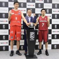 San-en’s Atsuya Ota (left), B. League chairman Masaaki Okawa and Kawasaki’s Ryusei Shinoyama pose for photographers at a news conference on Friday in Tokyo. B. League teams to play 60 games in first season