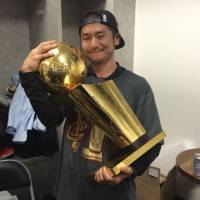 Cavaliers trainer Yusuke Nakayama cradles the championship trophy after Game 7 of the NBA Finals on June 19 in Oakland, California. Team trainer Nakayama revels in Cavaliers' long-awaited championship