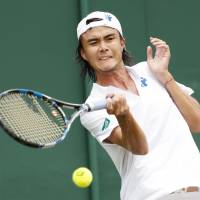 Taro Daniel plays a shot during his first-round defeat to Juan Monaco at Wimbledon on Tuesday. Nishikori practices after injury; Daniel falls to Monaco