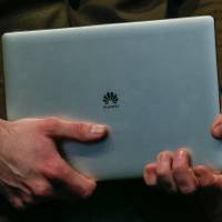 A model holds a Matebook tablet device manufactured by Huawei Technologies during a news conference ahead of the Mobile World Congress in Barcelona, Spain, in February. Huawei to enter Japan's laptop market
