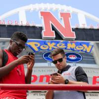 Jordy Tshimanga (left) and Brett Sapp look at their phones during a Pokemon Go event at Memorial Stadium in Lincoln, Nebraska, on Thursday. 'Pokemon Go' no ace in hole for Nintendo