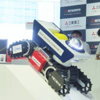 A Mitsubishi Heavy Industry Ltd. worker demonstrates Sakura No. 2, a spark-free robot suitable for use at disaster sites where explosive gases may be present. The display took place Tuesday at the company's office in Tokyo's Minato Ward. Mitsubishi Heavy unveils robot for use when flammable gas has leaked