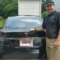 Joshua Brown stands by his new Tesla electric car near his home in Canton, Ohio, in this 2015 photo provided by his neighbor. Brown died in a Florida crash on May 7 in what is believed to be the first fatality from a car using self-driving technology. Fatal Tesla crash revs up criticism of on-road beta testing for self-driving vehicles