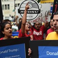 Activists protest outside of Trump Tower in New York on Thursday as they call for Wal-Mart to withdraw financial support from the Republican National Convention and support for the U.S. Republican presidential candidate Donal Trump. Trump foes urge Wal-Mart to skip Republican convention