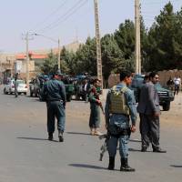 Afghan police soldiers inspect the site of a bomb attack, in Herat, Afghanistan, Saturday. Taliban attacks over in two days in Helmand province kill 24 police officers