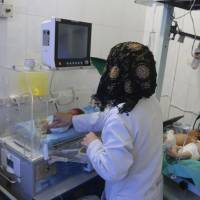 A nurse assists babies inside a nursery at a children's hospital that was partially damaged from recent airstrikes, in a rebel held area of Aleppo, Syria, Sunday. Rebels rocket Damascus after regime forces strike five Aleppo clinics