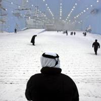 People are seen on the slope at Ski Dubai complex in the United Arab Emirates. Residents of and visitors to the emirate can new keep cool during the scorching Mideast summer: the company behind the city's indoor ski slope plans to let guests stay overnight in tents on the man-made snow on Fridays starting from July 29. Operator of Dubai ski slope to offer overnight camping in cooler conditions
