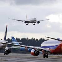 A passenger jet comes in for a landing and in view of a line of planes waiting to takeoff at Seattle-Tacoma International Airport last December. U.S. environmental regulators are moving to limit emissions from aircraft, ruling that jet engine exhaust is endangering human health by warming the planet. EPA finds jetliner pollution endangers public health, environment