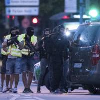 Special police forces prepare to search a neighboring shopping center outside the Olympia mall in Munich on Friday after at least nine people were killed in a shooting. German-Iranian man, 18, kills nine in Munich shooting rampage