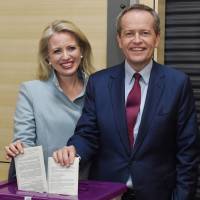 Opposition Labor Party leader Bill Shorten (left) and Australia's Prime Minister Malcolm Turnbull (right) vote on Saturday in national elections with their wives. Australia in political limbo after voters punish government