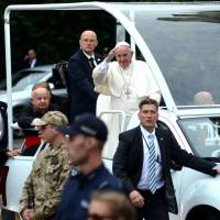 Pope Francis and Stanislaw Dziwisz (back, left), Polish prelate of the Roman Catholic Church, drive in the popemobile to the Archibishops House in Krakow, Poland, Wednesday. Pope says 'world at war because it has lost peace' but religion not to blame