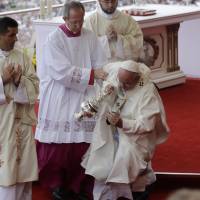 Pope Francis is helped by Vatican Master of Ceremonies, Mons. Guido Marini as he stumbles on the altar during a mass in Czestochowa, Poland, on Thursday. Pope Francis falls in Poland, escapes injury