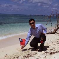 This handout picture taken and released Wednesday by the office of Kuomintang (KMT) lawmaker Johnny Chiang shows Chiang holding a Taiwanese flag during a visit to Taiping island in the South China Sea. Taiwan lawmakers visit South China Sea islet to assert sovereignty