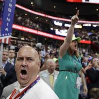 Illinois delegate Christian Gramm (left) and other delegates react as some call for a roll call vote on the adoption of the rules during first day of the Republican National Convention in Cleveland Monday. Trump foes' suspicions prove true as RNC, followers squelch roll call bid