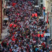 Demonstrators march with national flags on Istiklal avenue in Istanbul on Sunday. Thousands of flag-waving Turks massed for the first cross-party rally to condemn the coup attempt against President Recep Tayyip Erdogan, amid an ongoing purge of suspected state enemies. Turks protest coup; reports of torture add to government's woes