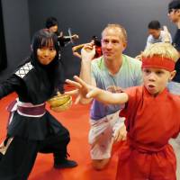 Tourists dressed in ninja outfits experience throwing shuriken stars at Nagoya Castle in Nagoya's Naka Ward. Nagoya Castle opens ninja school to train 'apprentices'