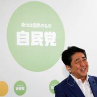 Prime Minister Shinzo Abe, who is also leader of the Liberal Democratic Party, smiles during a news conference at LDP headquarters in Tokyo on Sunday after the ruling bloc swept to victory in the Upper House election. Over 50% in poll do not think Abenomics will lift Japan's economy