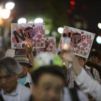 People take part in a protest against the Trans-Pacific Partnership trade pact in Tokyo in May. BLOOMBERG TPP, security dog Clinton, Trump presidential bids