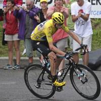 Britain’s Chris Froome rides with blood running down his leg after crashing during the 19th stage of the Tour de France from Albertville to Saint-Gervais Mont Blanc on Friday. Froome keeps lead despite crash