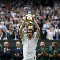 Great Britain's Andy Murray celebrates winning the mens Wimbledon singles final Sunday against Canada's Milos Raonic with the trophy. Murray tops Raonic to claim second Wimbledon title