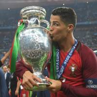 Cristiano Ronaldo kisses the trophy after Portugal’s victory in the Euro 2016 final on July 10, in Saint-Denis, France. Ronaldo, Messi on UEFA award shortlist
