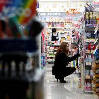 A shopper browses items at a Tokyo pharmacy in this 2013 file image. As Abenomics loses shine, Japan's shoppers seek bargains