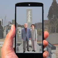 The app “Spot message” shows video of a couple at a grave site. 'Pokemon Go'-like app allows living to plan missives from beyond the grave